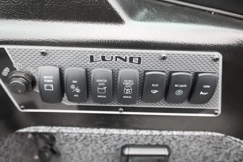 Slide: The Image of Control panel of 2026 Lund 1775 Impact XS Sport boat with labeled switches. - 29