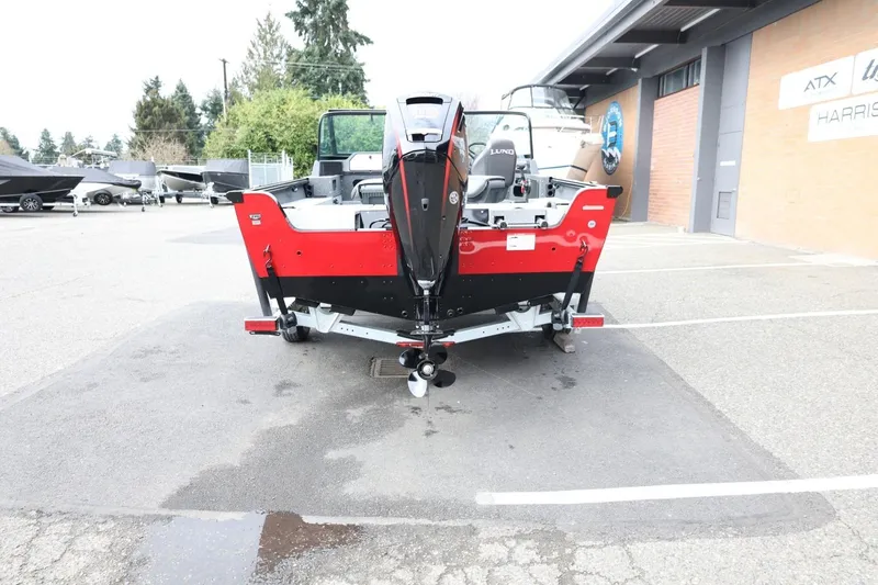 Slide: The Image of 2026 Lund 1775 Impact XS Sport boat, red and black, parked outdoors. - 7