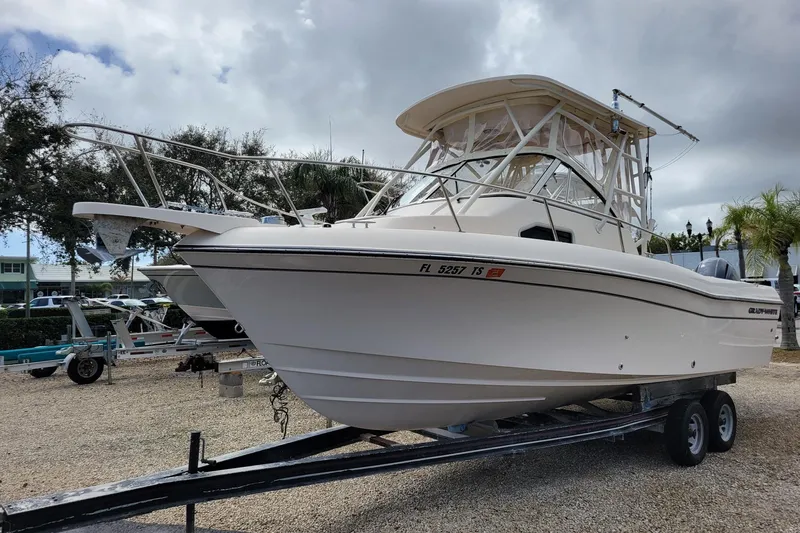 The Image of 2023 Grady-White Gulfstream 232 boat on trailer, parked outdoors under cloudy sky. - 0