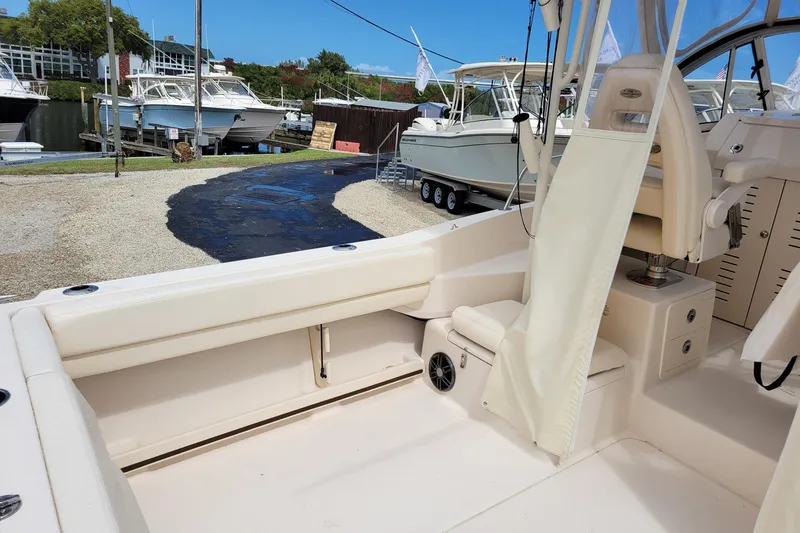 Slide: The Image of 2023 Grady-White Gulfstream 232 boat interior at a marina, showcasing seating and storage. - 10