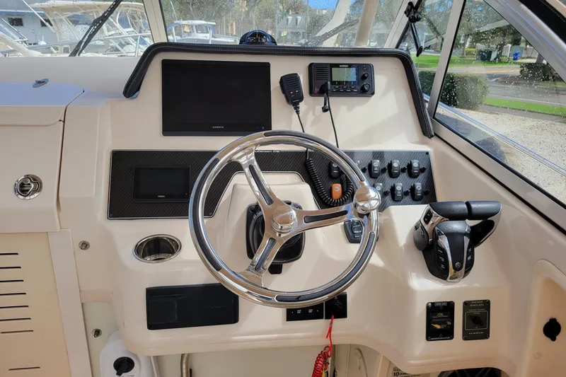 Slide: The Image of 2023 Grady-White Gulfstream 232 helm with steering wheel and control panel. - 12
