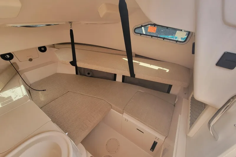 Slide: The Image of 2023 Grady-White Gulfstream 232 cabin interior with beige cushions and window. - 15