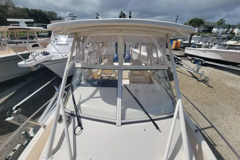 Slide: The Image of 2023 Grady-White Gulfstream 232 boat, front view, docked with clear canopy and windshield. - 17