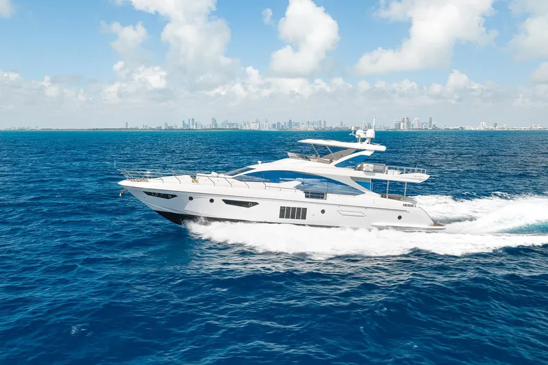 The Image of Luxurious 2015 Azimut 80 yacht cruising on open blue sea with city skyline backdrop. - 0