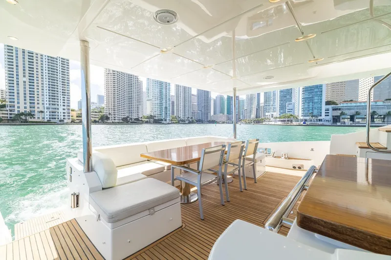 Slide: The Image of Luxurious 2015 Azimut 80 yacht deck with city skyline view, featuring elegant seating and dining area. - 8