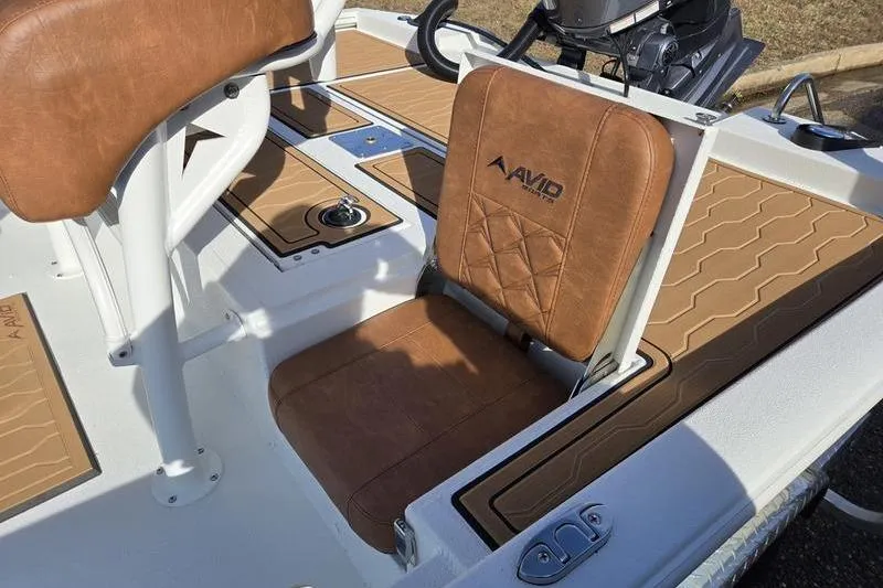 Slide: The Image of 2026 Avid 21 FSX boat interior with brown leather seating and deck details. - 14