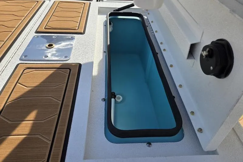 Slide: The Image of 2026 Avid 21 FSX boat interior with open storage compartment and wood-textured flooring. - 15