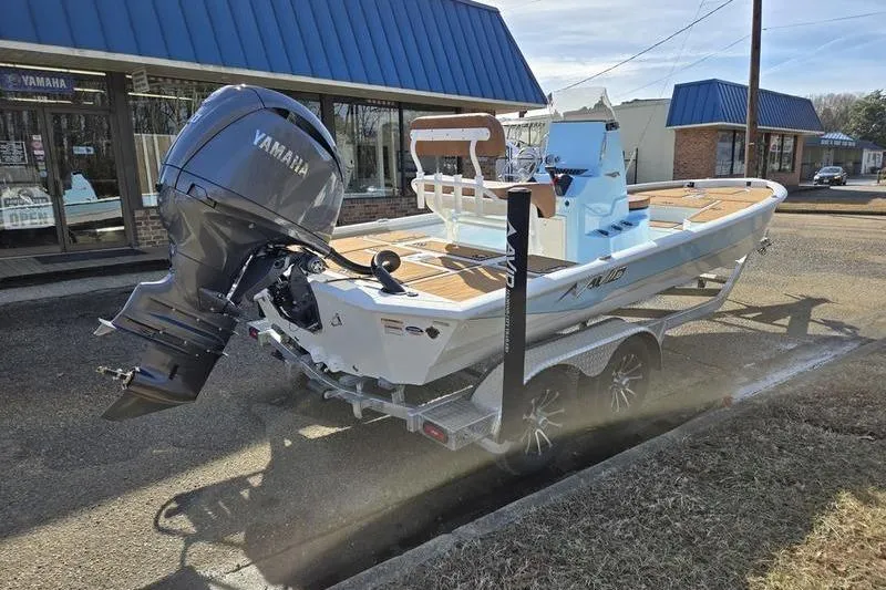 Slide: The Image of 2026 Avid 21 FSX boat on trailer with Yamaha outboard motor, parked outside dealership. - 2