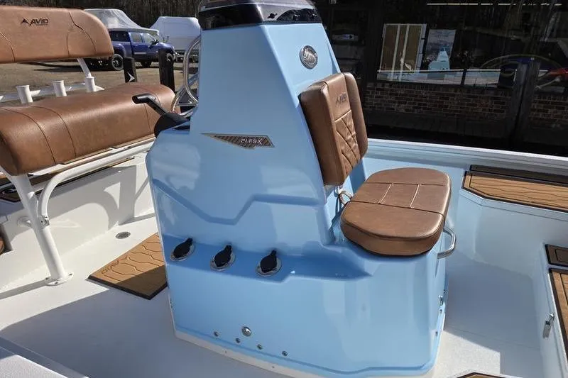 Slide: The Image of 2026 Avid 21 FSX boat interior with blue console and brown seating. - 5