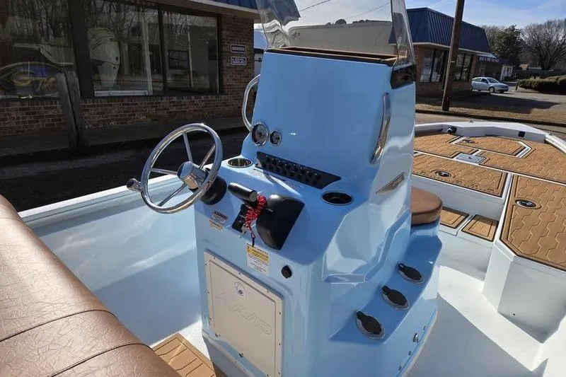 Slide: The Image of 2026 Avid 21 FSX boat console with steering wheel and controls, light blue exterior. - 8