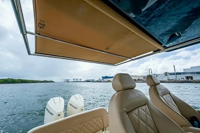 Slide: The Image of 2019 Chris-Craft Catalina 30 boat with Mercury engines, featuring luxurious seating and a retractable canopy. - 19