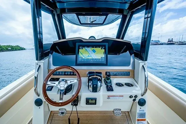 Slide: The Image of 2019 Chris-Craft Catalina 30 helm with navigation display and steering wheel, overlooking the ocean. - 23