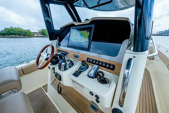 Slide: The Image of 2019 Chris-Craft Catalina 30 helm with modern navigation system and wooden accents. - 24