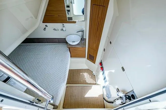 Slide: The Image of 2019 Chris-Craft Catalina 30 cabin interior with bed, sink, and wooden accents. - 33