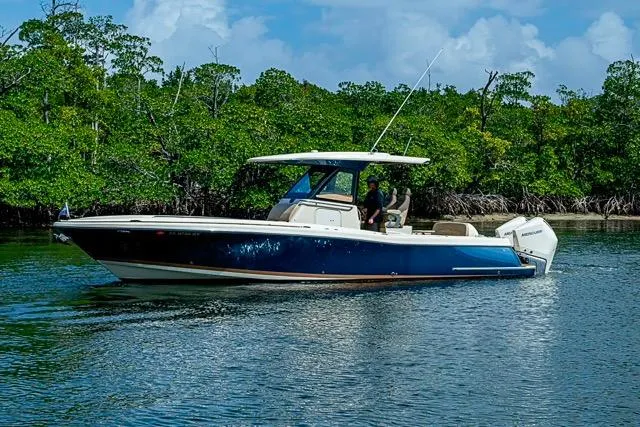Slide: The Image of 2019 Chris-Craft Catalina 30 boat cruising on a calm river with lush greenery. - 36