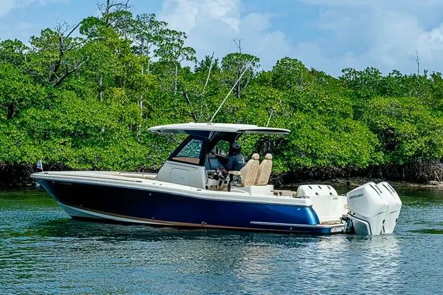 Slide: The Image of 2019 Chris-Craft Catalina 30 boat cruising near lush green shoreline. - 37