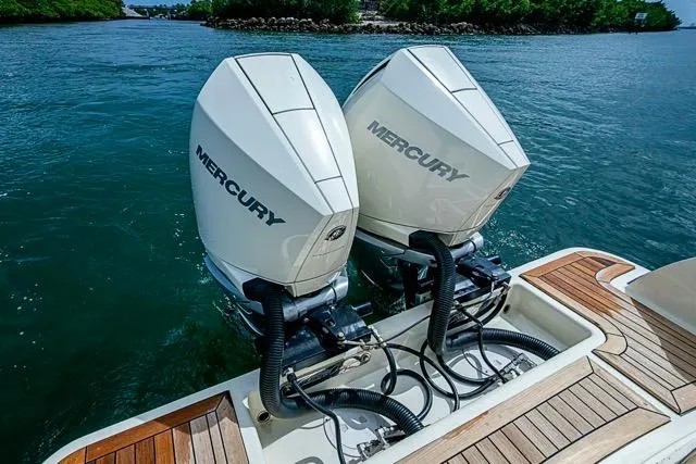 Slide: The Image of Twin Mercury outboard engines on a 2019 Chris-Craft Catalina 30, docked on clear water. - 9