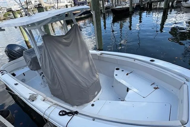 Slide: The Image of 2024 Sea Hunt Ultra 219 boat docked, featuring a covered console and spacious seating. - 10