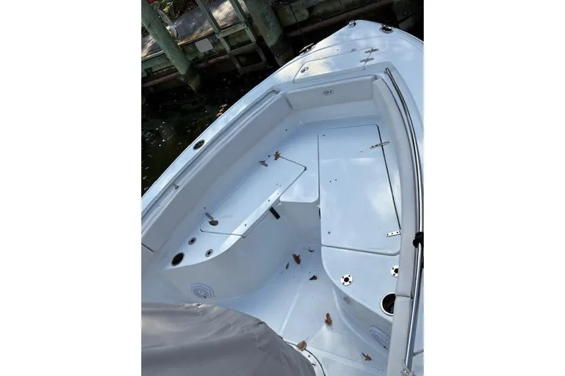 Slide: The Image of 2024 Sea Hunt Ultra 219 boat interior with clean white deck and seating area. - 12