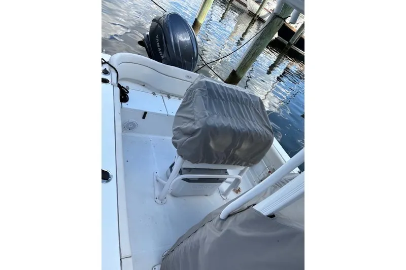 Slide: The Image of 2024 Sea Hunt Ultra 219 boat interior with covered seating and Yamaha outboard motor. - 14