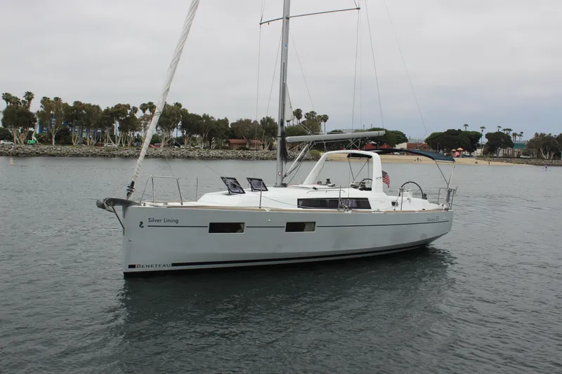 Slide: The Image of 2015 Beneteau Oceanis 35 sailboat on calm water, clear sky background. - 2