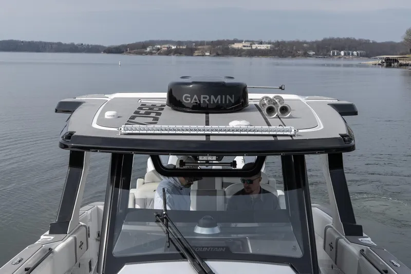 Slide: The Image of 2026 Fountain 38 SCX boat on calm water, featuring Garmin equipment. - 13