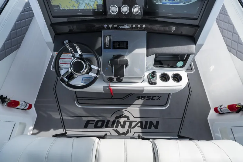 Slide: The Image of 2026 Fountain 38 SCX boat cockpit with steering wheel, controls, and navigation screens. - 29