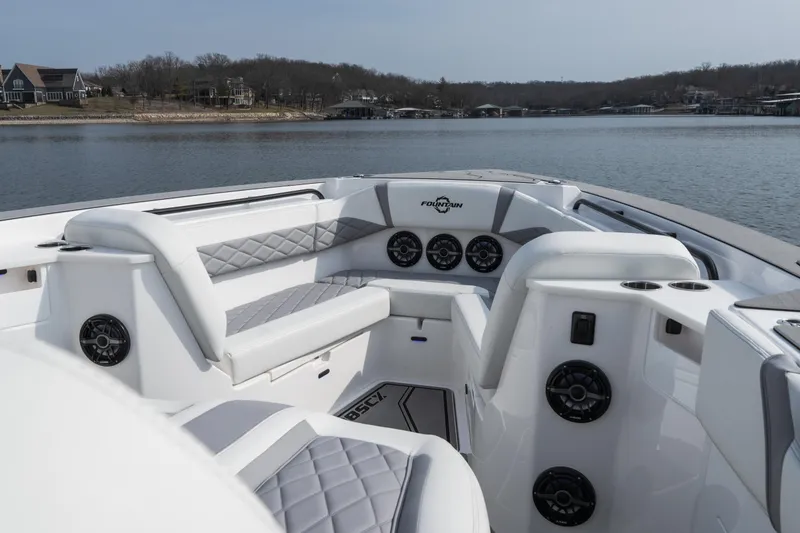 Slide: The Image of 2026 Fountain 38 SCX boat interior with luxurious seating and speakers on a serene lake. - 30
