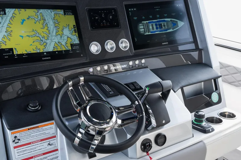 Slide: The Image of 2026 Fountain 38 SCX boat dashboard with Garmin navigation screens and sleek steering wheel. - 35
