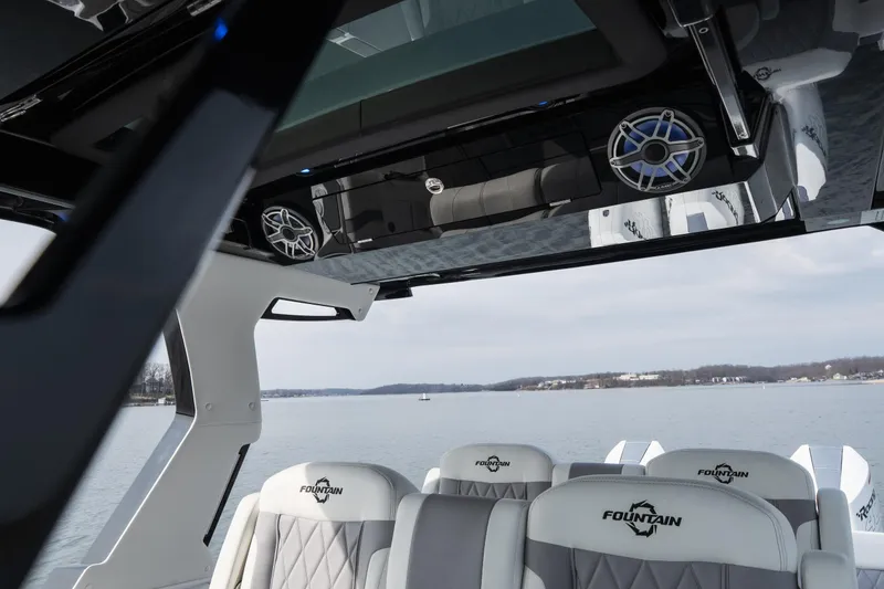 Slide: The Image of 2026 Fountain 38 SCX boat interior with luxury seating and speakers on a calm lake. - 38