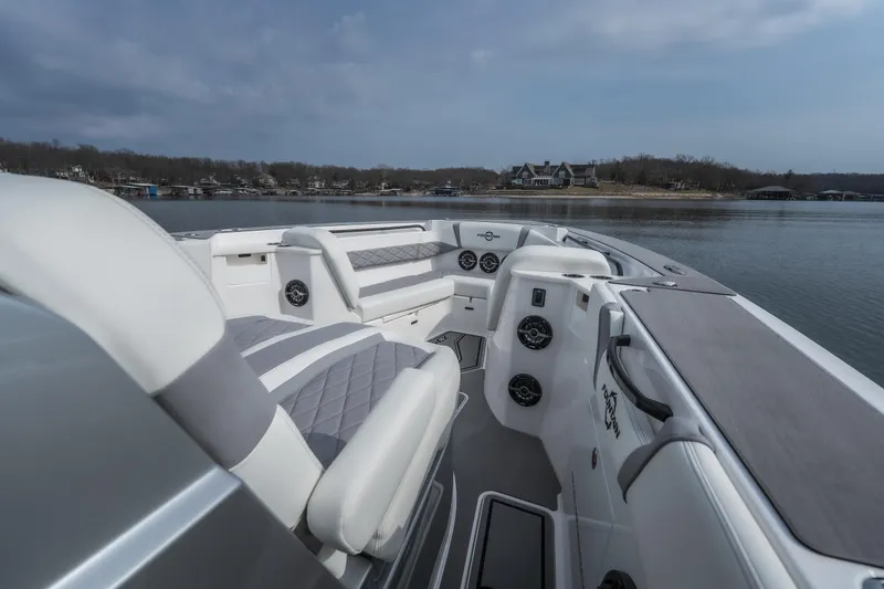 Slide: The Image of 2026 Fountain 38 SCX boat interior with luxurious seating on a calm lake. - 5