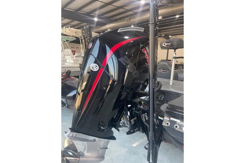 Slide: The Image of 2023 Triton 21 XrT boat with powerful outboard motor in showroom. - 2