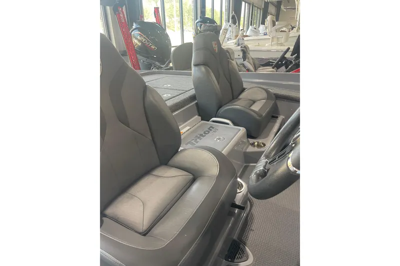 Slide: The Image of 2023 Triton 21 XrT boat interior with black seats and steering wheel. - 4