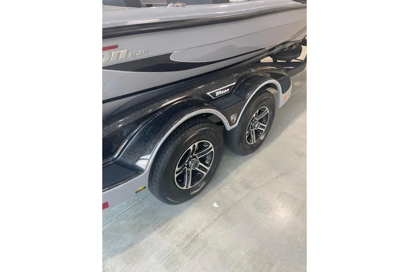 Slide: The Image of 2023 Triton 21 XrT boat trailer with dual black wheels and sleek design. - 9