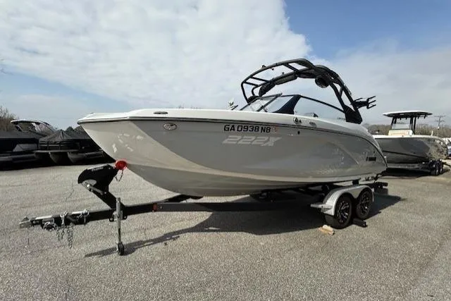 Slide: The Image of 2023 Yamaha Boats 222XE on trailer, sleek design, parked outdoors under cloudy sky. - 4