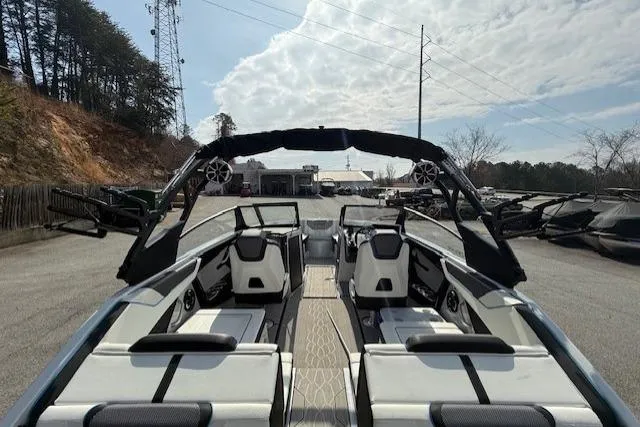 Slide: The Image of 2023 Yamaha Boats 222XE with sleek interior design, parked outdoors under a cloudy sky. - 8