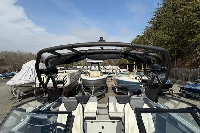 Slide: The Image of 2023 Yamaha Boats 222XE in a marina, surrounded by other boats and trees. - 9