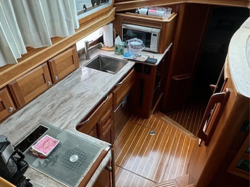 Slide: The Image of 2017 Sabre 45 Salon Express yacht kitchen with wood cabinetry and modern appliances. - 7