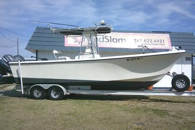 The Image of 2002 Parker 2501 Center Console boat on trailer, parked outside dealership. - 1