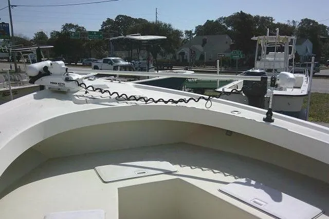 Slide: The Image of 2002 Parker 2501 Center Console boat docked, featuring a Minn Kota trolling motor. - 14