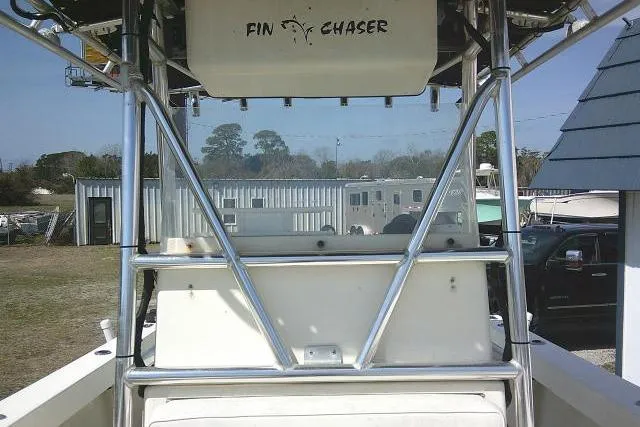 Slide: The Image of 2002 Parker 2501 Center Console boat with "Fin Chaser" label, docked outdoors. - 22