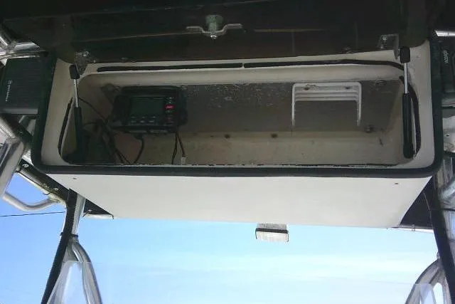 Slide: The Image of 2002 Parker 2501 Center Console storage compartment with radio equipment. - 34