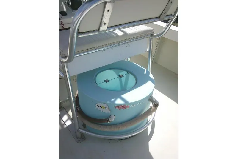 Slide: The Image of 2002 Parker 2501 Center Console boat with a blue livewell under a cushioned seat. - 37