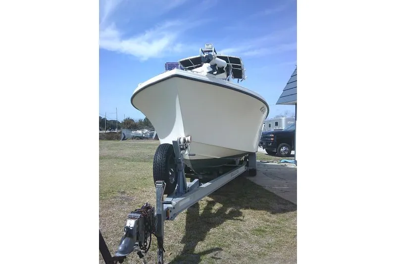 Slide: The Image of 2002 Parker 2501 Center Console boat on trailer, parked outdoors under blue sky. - 4