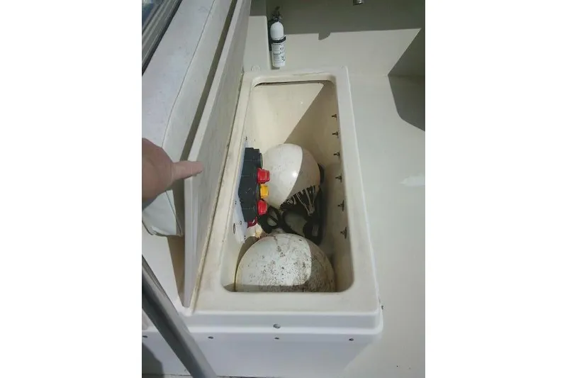 Slide: The Image of Open storage compartment on 2002 Parker 2501 Center Console boat with safety equipment. - 42