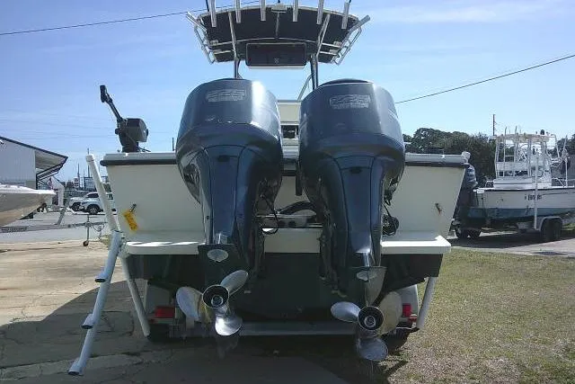 Slide: The Image of 2002 Parker 2501 Center Console boat with dual outboard motors, docked on land. - 8