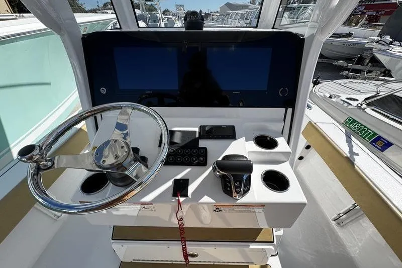 Slide: The Image of 2026 Sportsman Masters 247 Bay Boat helm with steering wheel and control panel. - 15