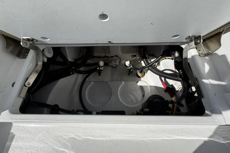 Slide: The Image of 2026 Sportsman Masters 247 Bay Boat storage compartment with visible wiring and components. - 24