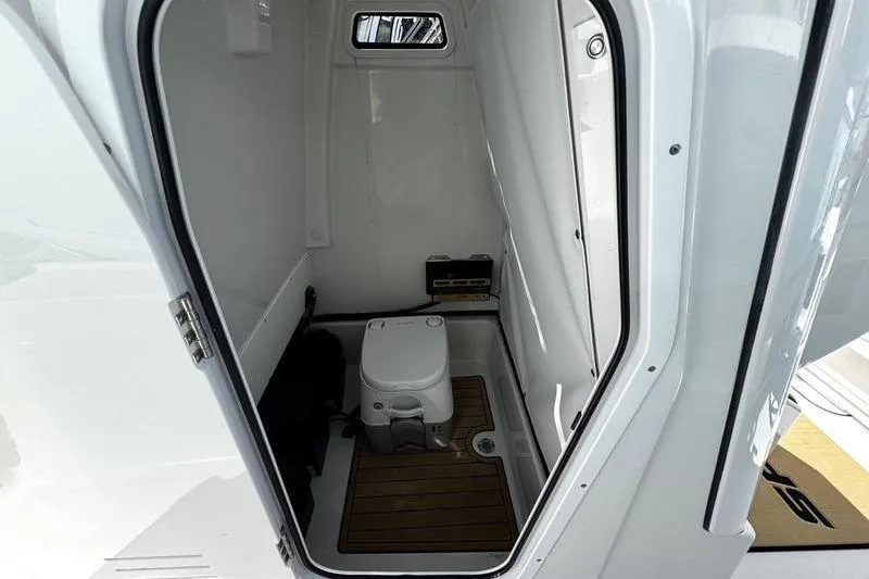 Slide: The Image of 2026 Sportsman Masters 247 Bay Boat interior with compact marine toilet. - 14