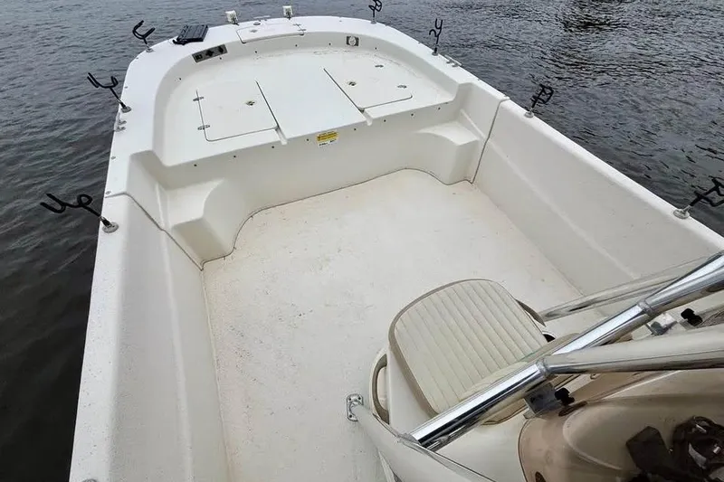 Slide: The Image of 2017 Carolina Skiff 238 DLV boat interior with rod holders on calm water. - 10